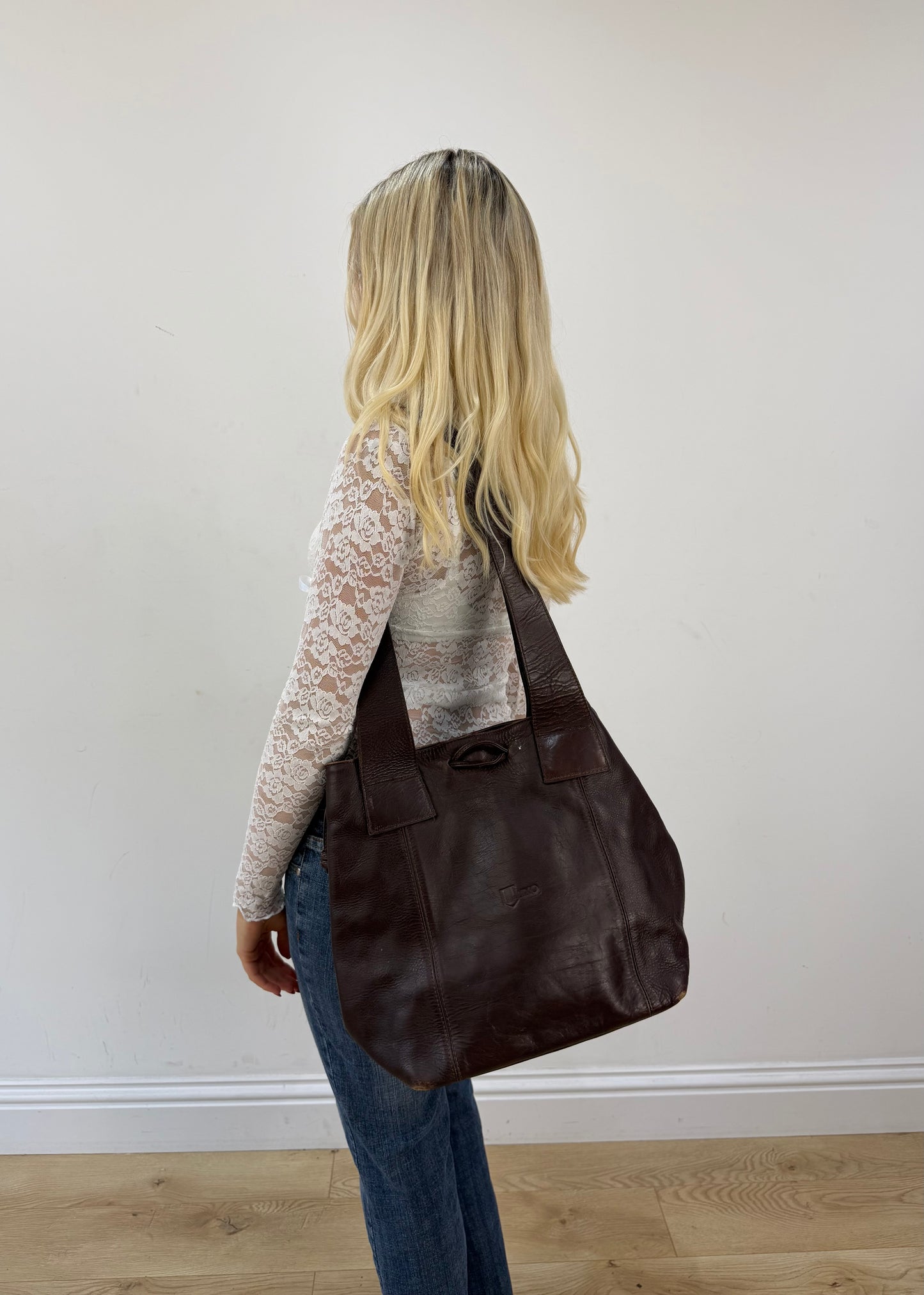 thiros black leather shoulder bag with white stitching and gold buckles 1