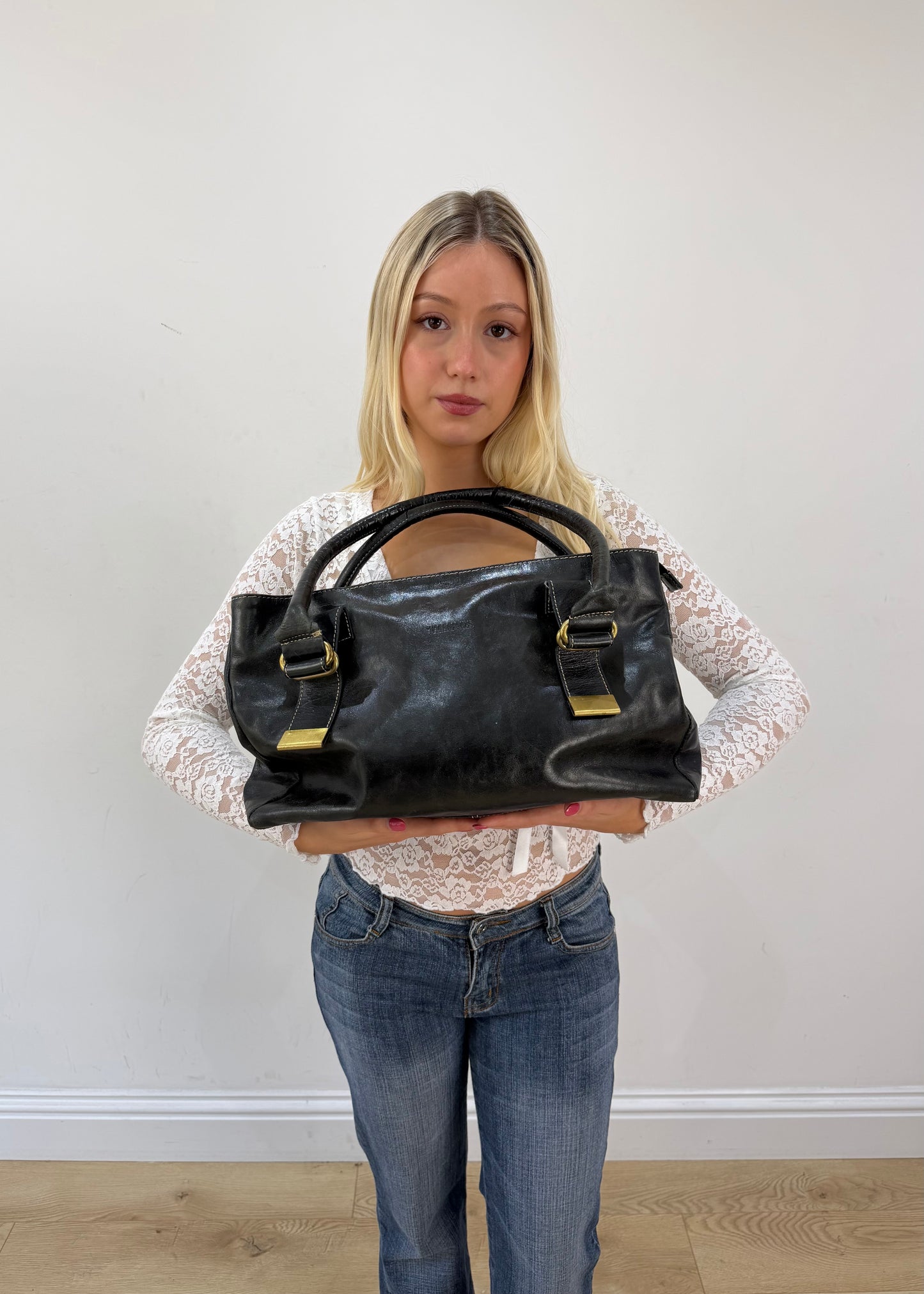 thiros black leather shoulder bag with white stitching and gold buckles 3