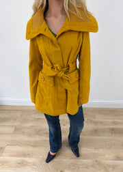 small yellow belted trench coat headless close-up