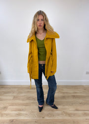small yellow belted trench coat worn open