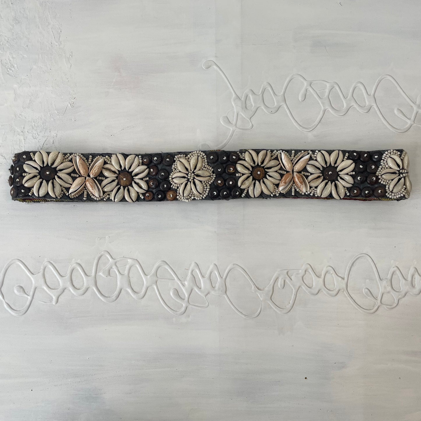 white and brown shell belt