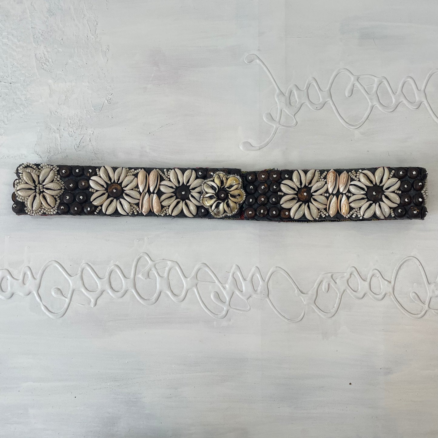 white and brown shell belt